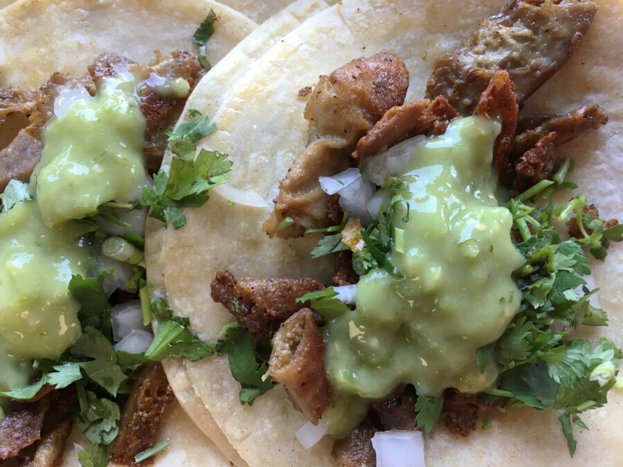 tripe tacos with green sauce, cilantro and onion.