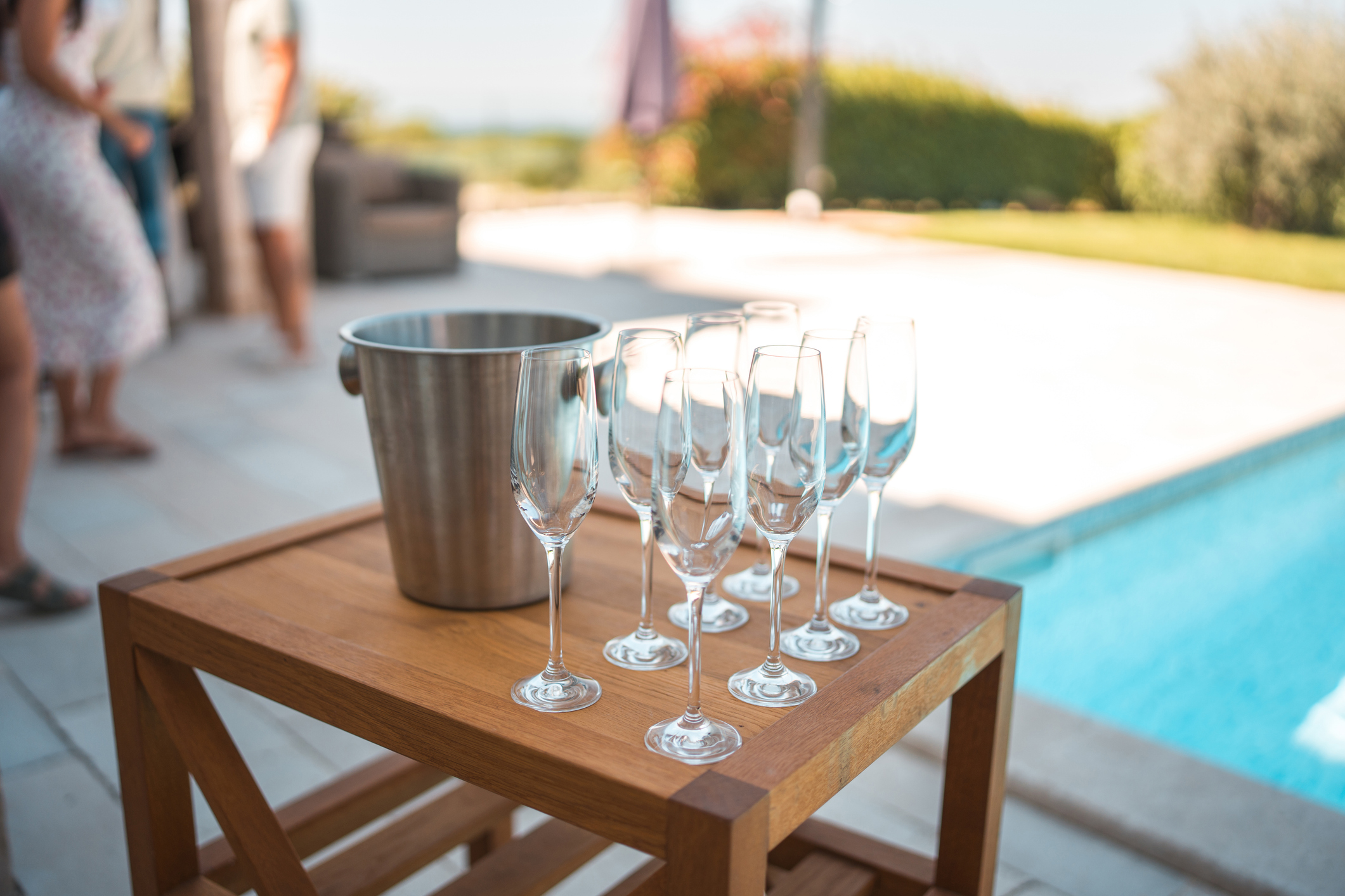 The villa pool party comes alive ready to pop open champagne bottles for diverse group of friends.