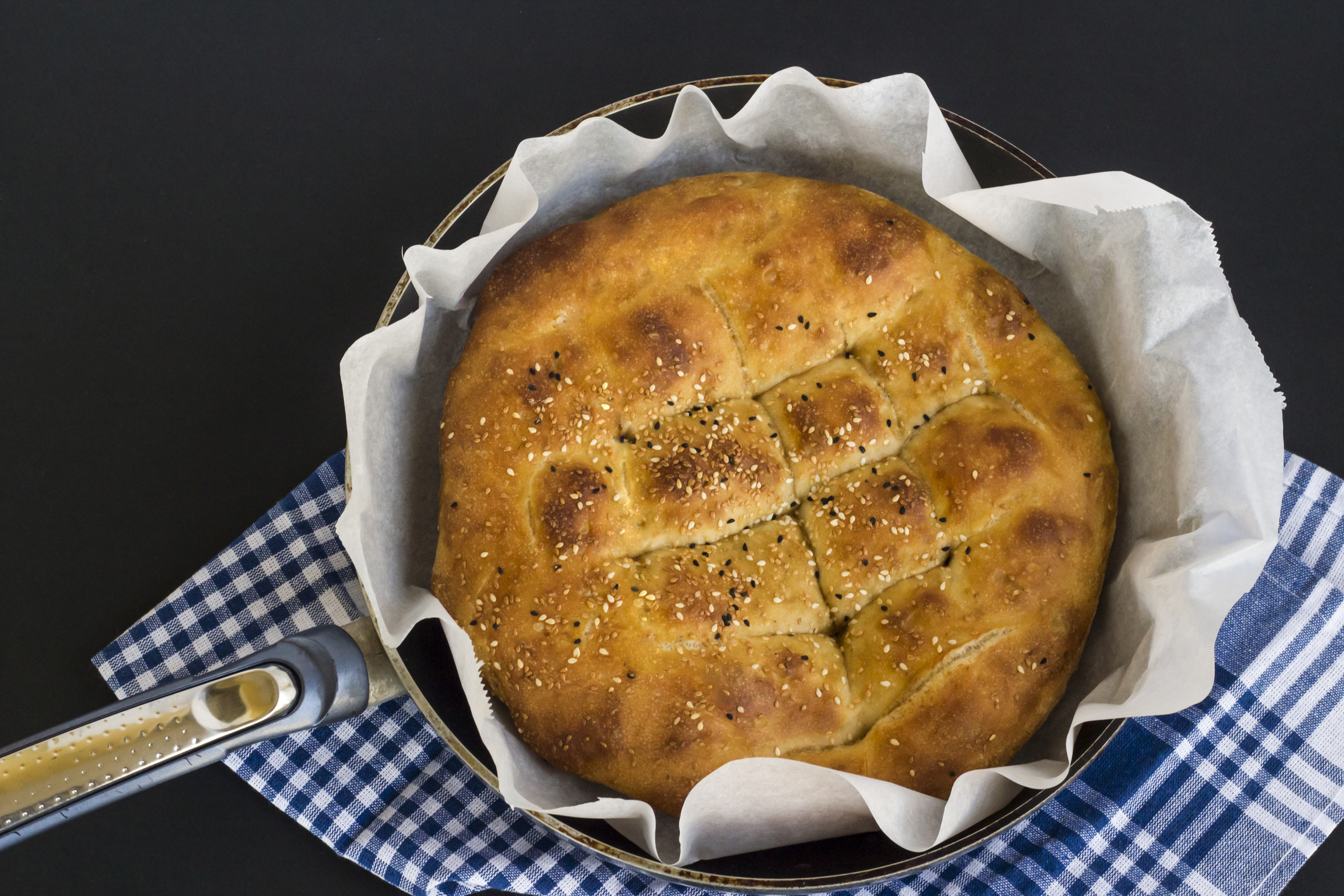 Traditional Turkish,Homemade Ramadan Bread in metal pan with fabric napkin and oven paper.Top view