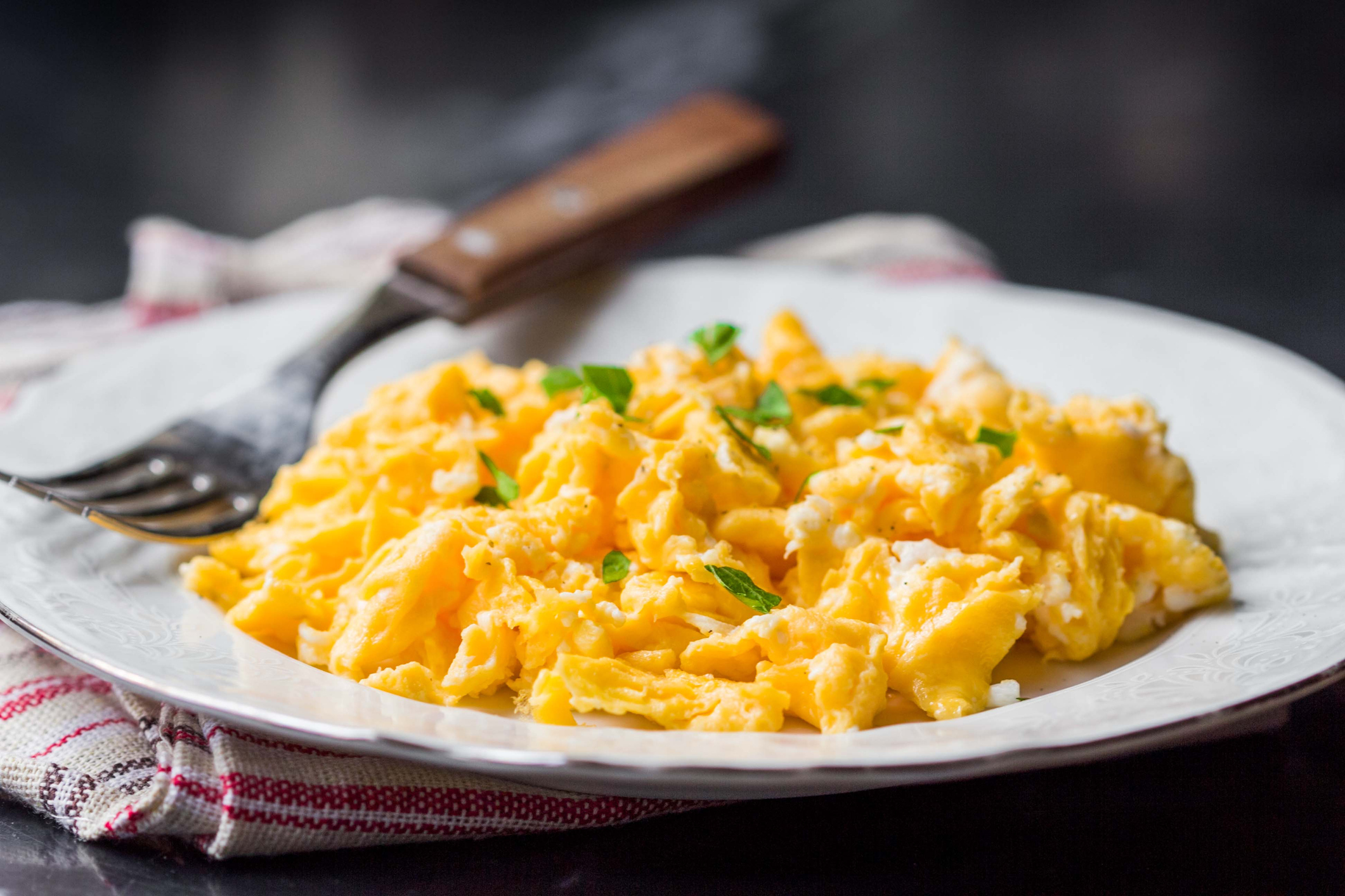 Scrambled eggs, omelets with herbs, delicious simple morning breakfast