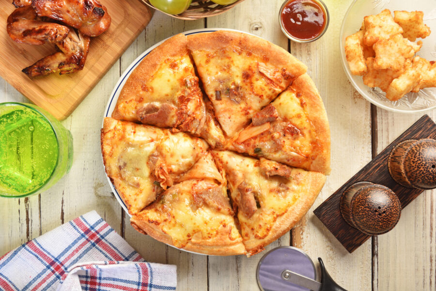 pizza pie with kimchi, cheese and pork on wooden table.