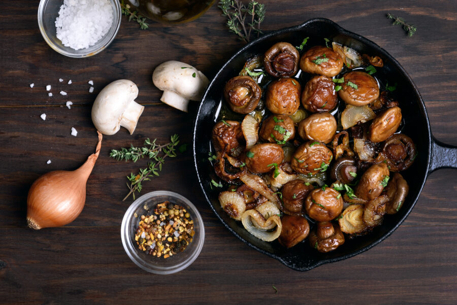 fried mushrooms in frying pan on wooden table, top view