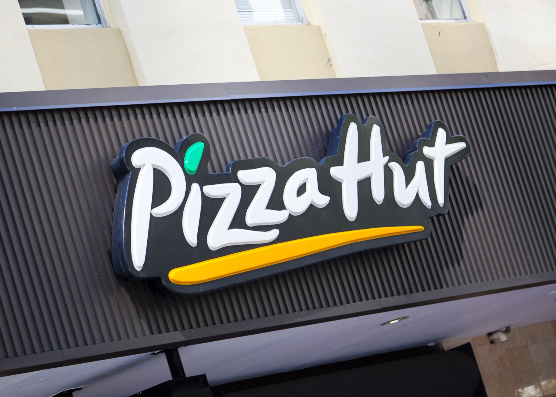Pizza Hut logo sign mounted on the exterior of a restaurant building.