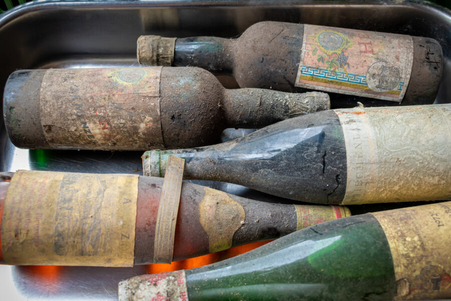 very old wine bottles with deposits from long cellar storage as offers at a flea market