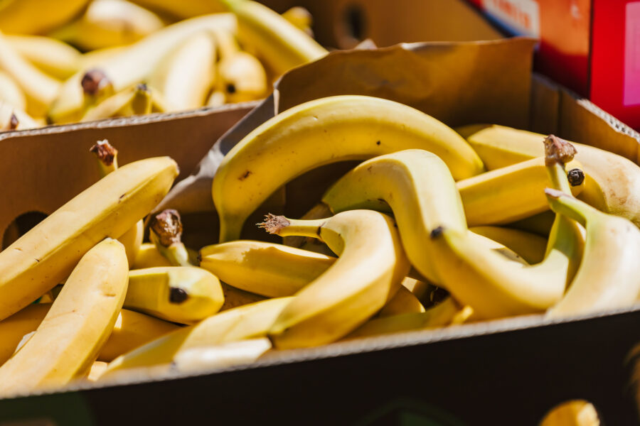 A box filled with fresh, ripe yellow bananas