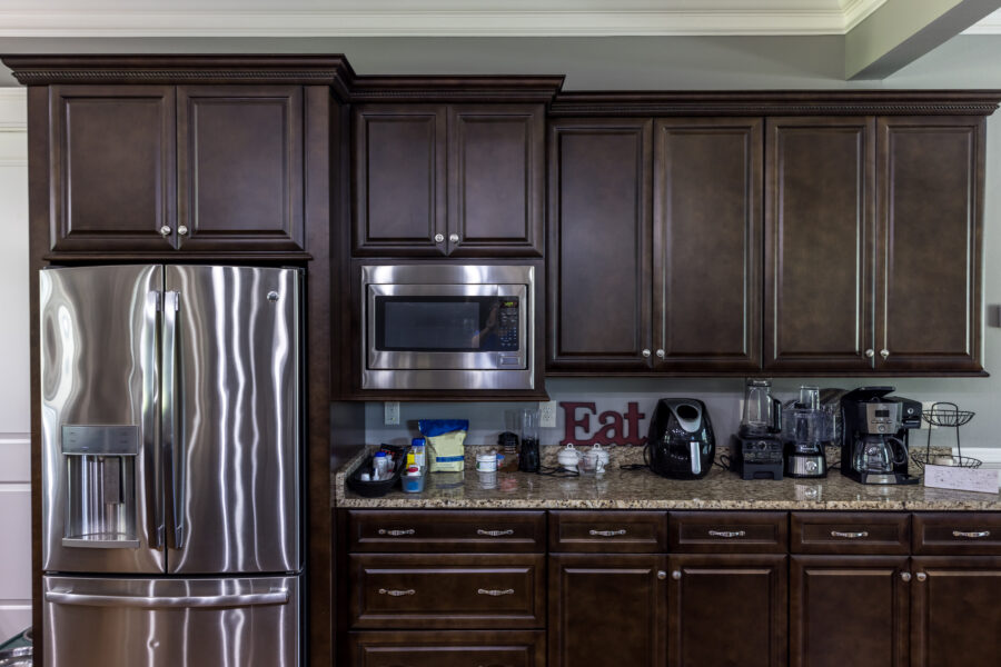 A modern kitchen with dark wood cabinets and stainless steel appliances.