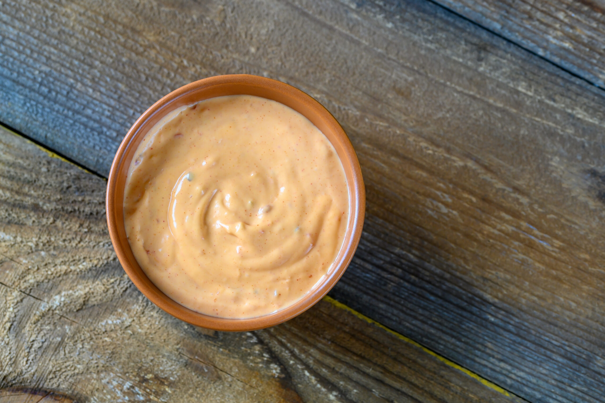 Bowl of Thousand Island dressing on wooden table