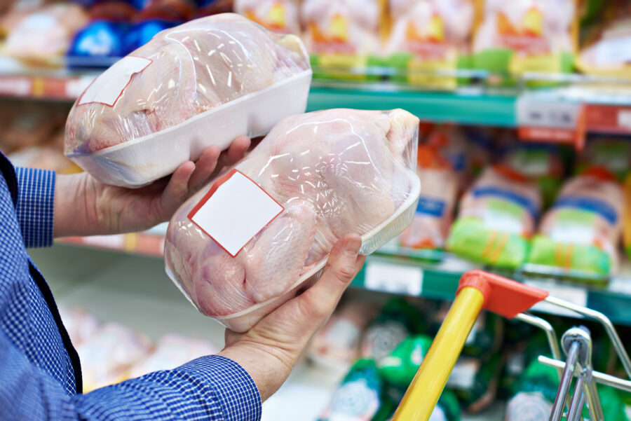 Buyer man chooses chicken meat in a shop