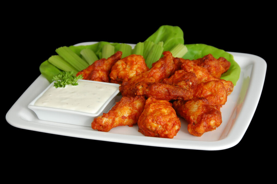 Classic Buffalo Wings: chicken wings in a spicy sauce, served with celery sticks and blue cheese dip.