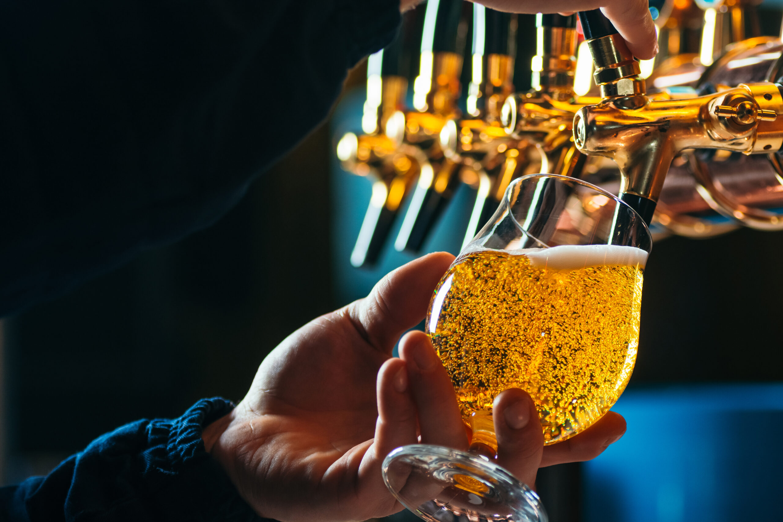 Close up of bartender pouring draft beer in glass