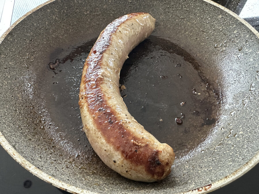 close-up of german sausage in frying pan