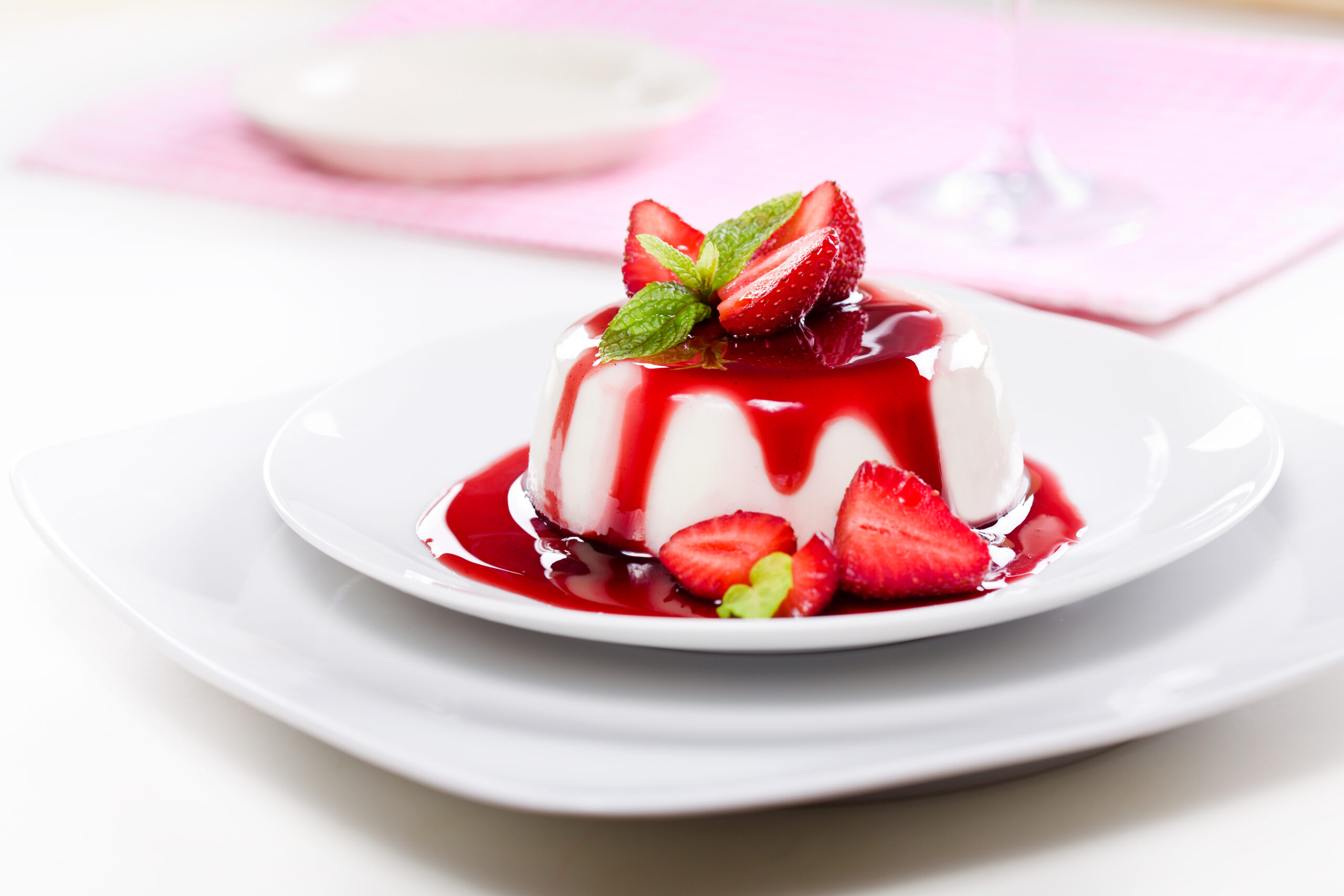 Close up photograph of a fancy panna cotta with strawberries