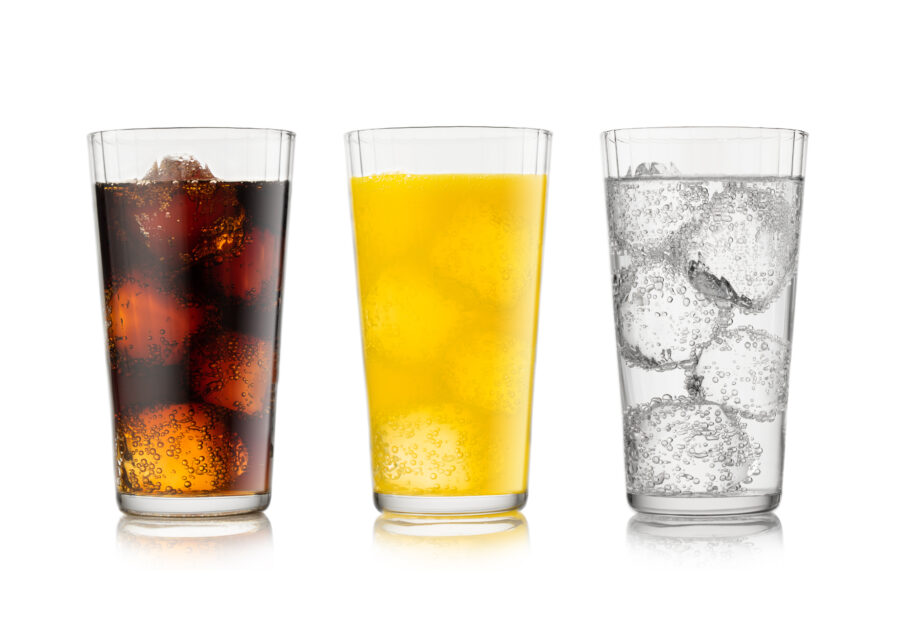 Cola soda drink with lemonade and orange soda with ice cubes and bubbles on white.