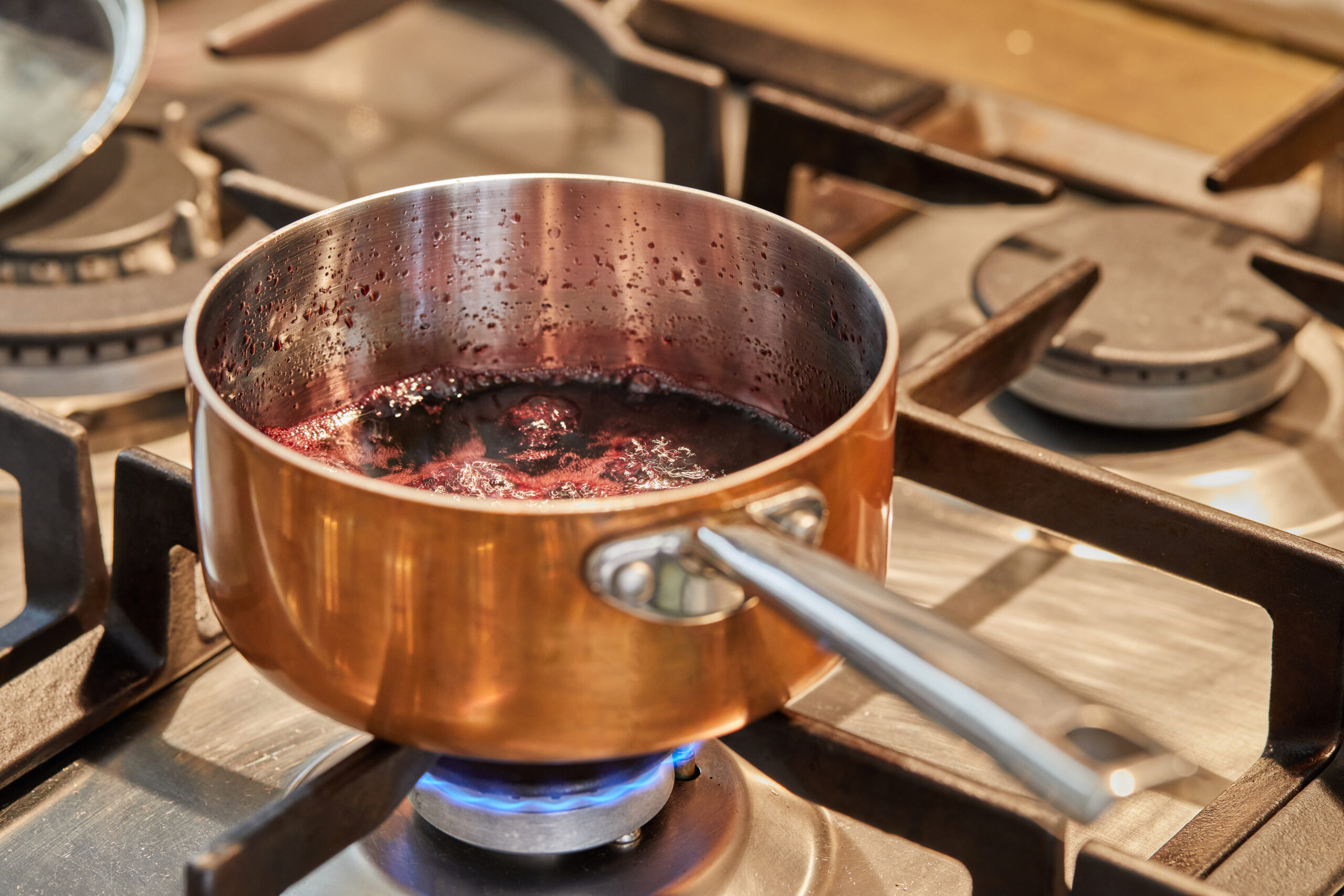 Copper saucepan over low heat on stove to make sauce.