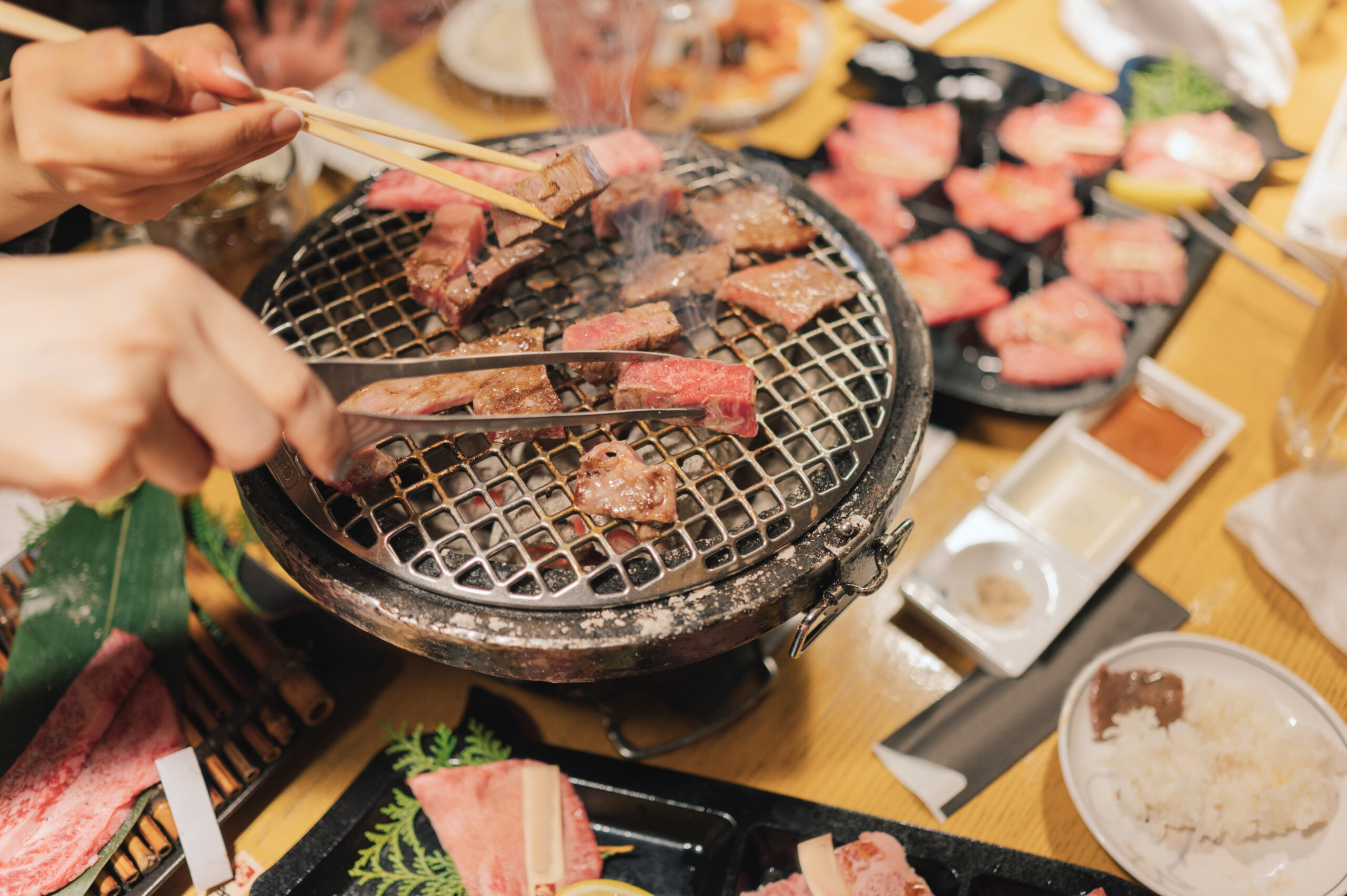 Crop shot asia smile women with Wagyu A5 Steak stick with BBq sauce and pepper Osaka japan streetfood