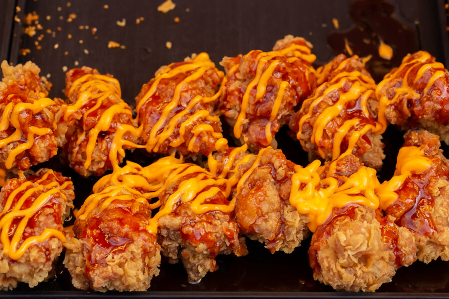 Fried chicken topped with mayonnaise on wooden table