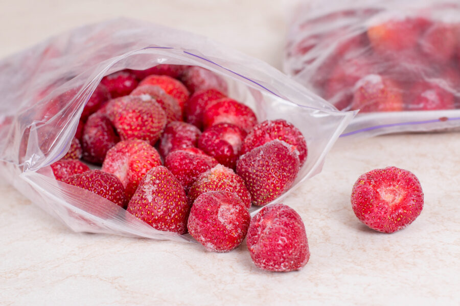 Frozen strawberries in bags, close up.