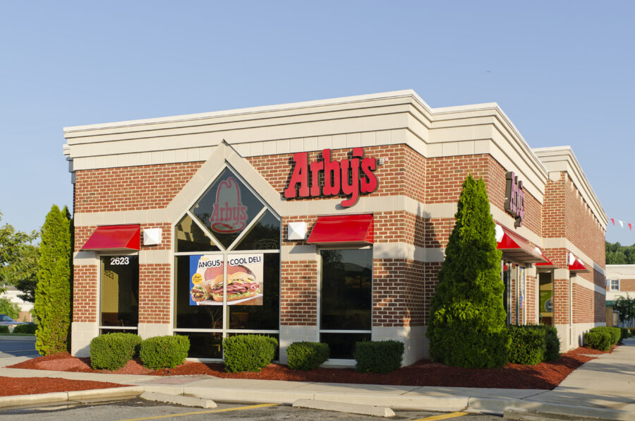 A standalone Arby's restaurant in a modern shopping center