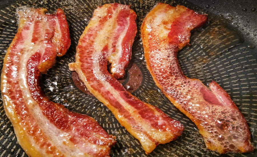 sizzling bacon strips, fried in non stick frying pan