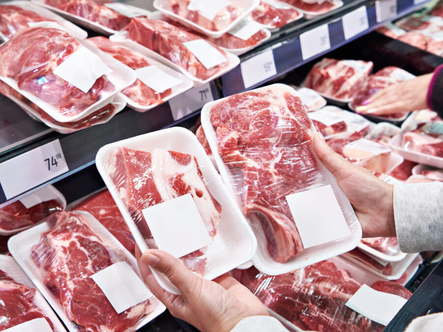 Hand with package meat beef in store