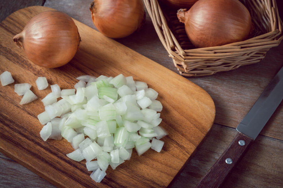 Fresh chopped onions on wooden cutting board