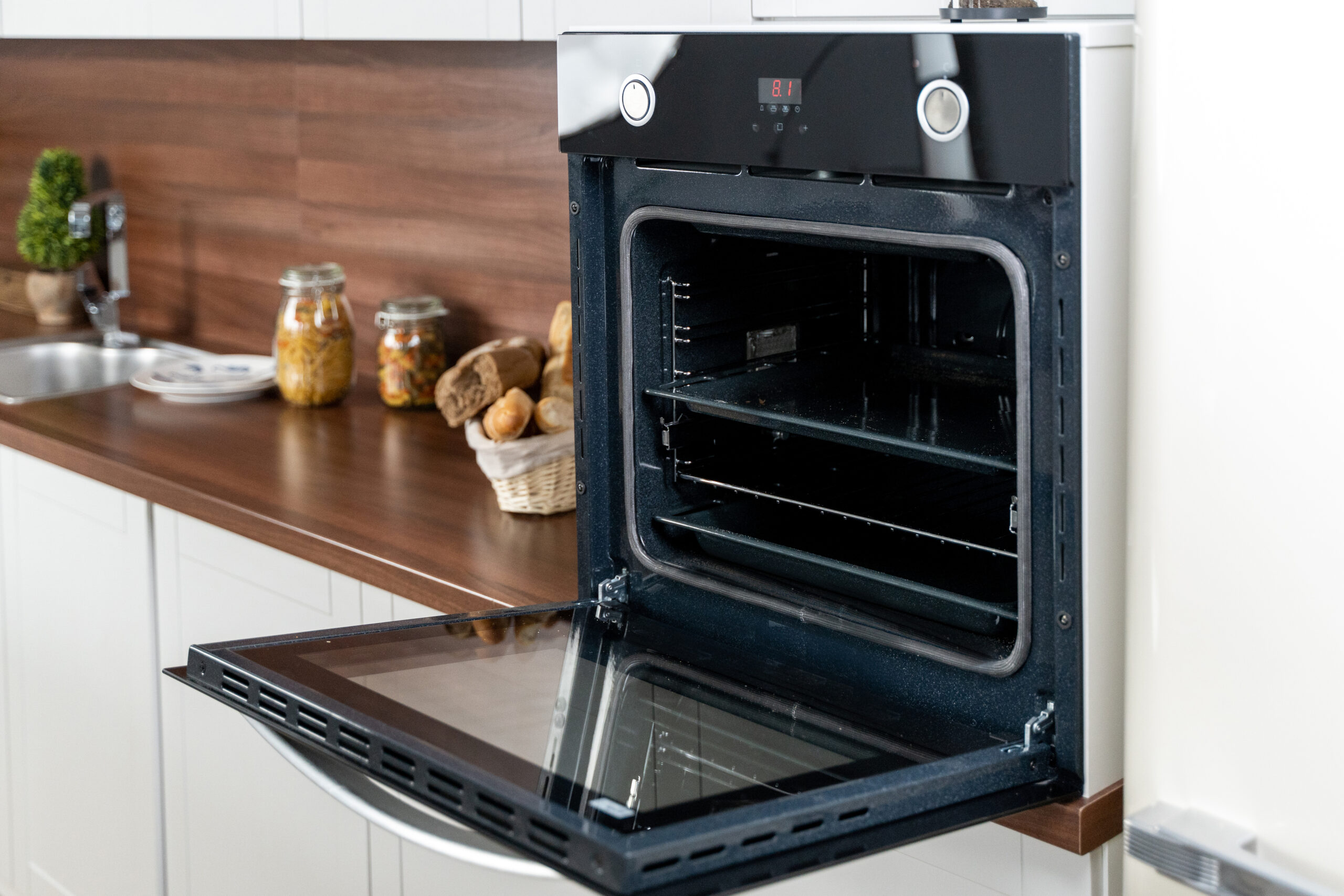 Black new open oven on white rustic kitchen