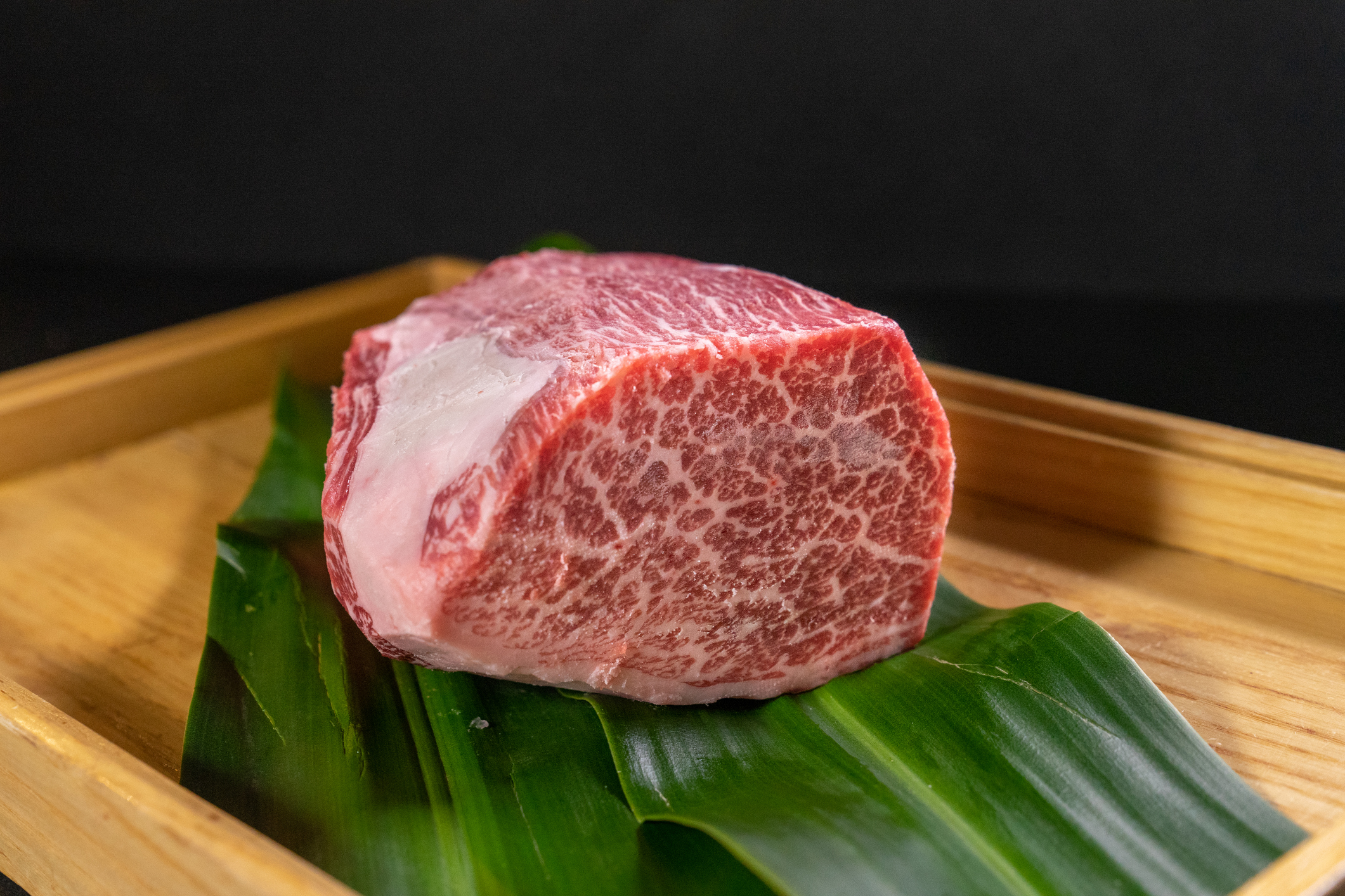A closeup of raw wagyu cut steak on a wooden board on the table