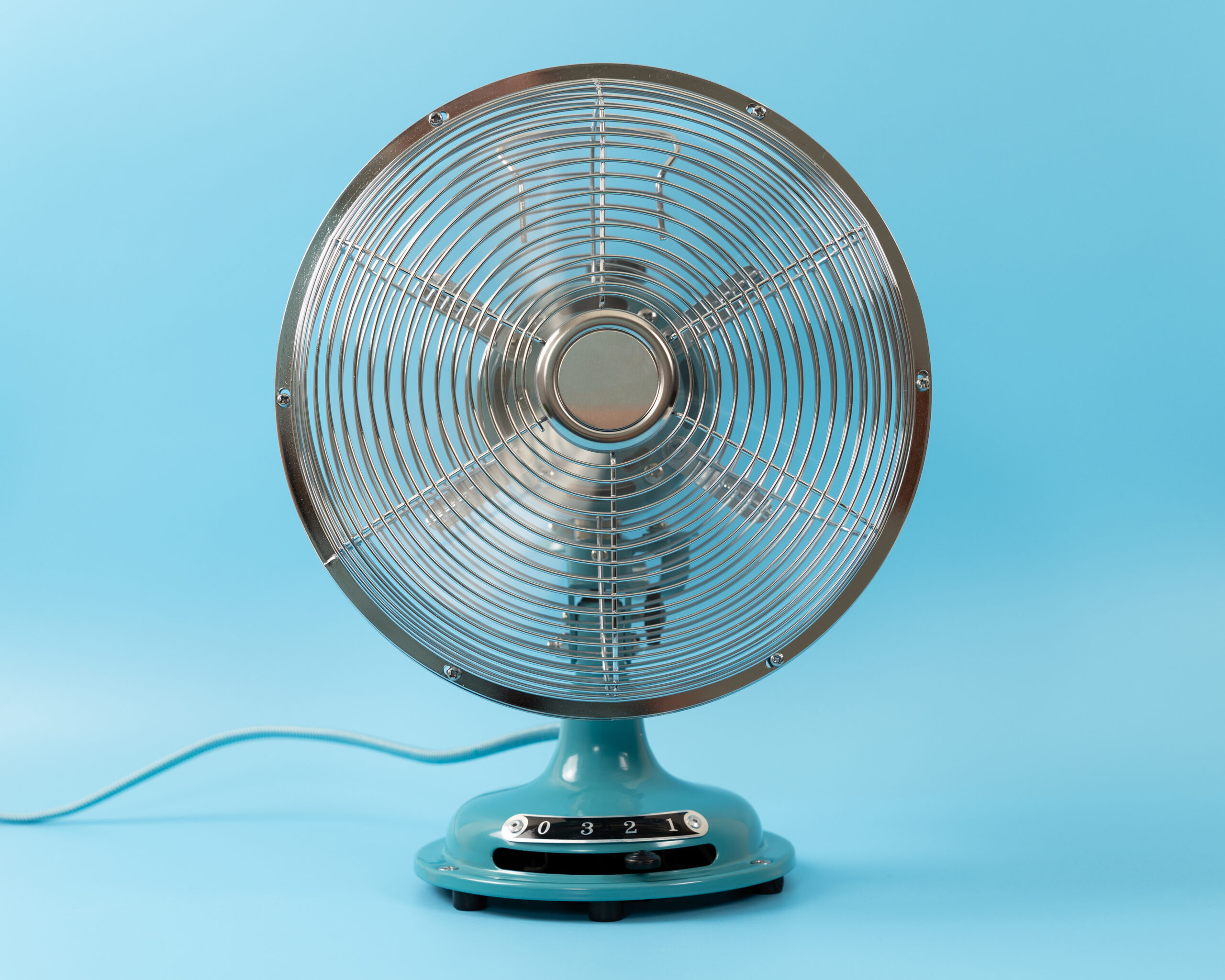 Retro vintage tabletop fan isolated on a blue background