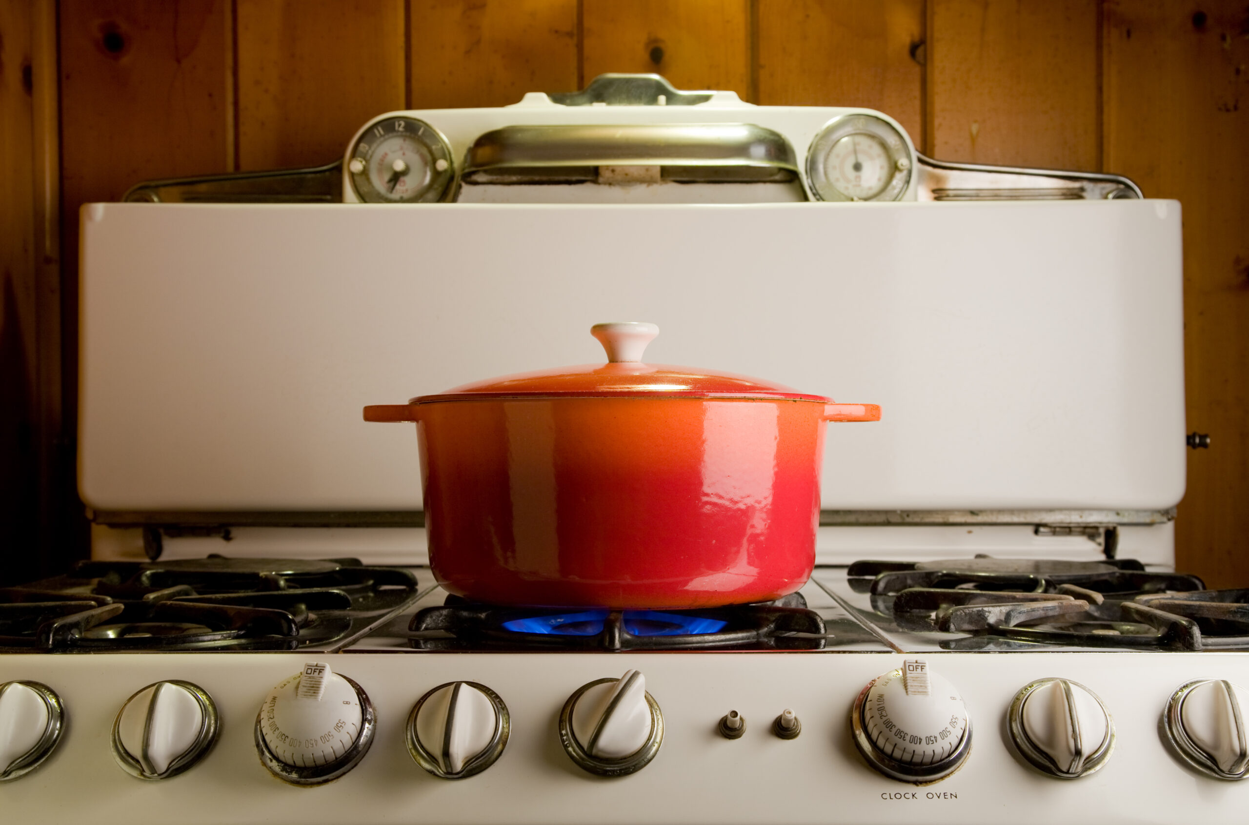 red cast iron pot cooking on antique stove