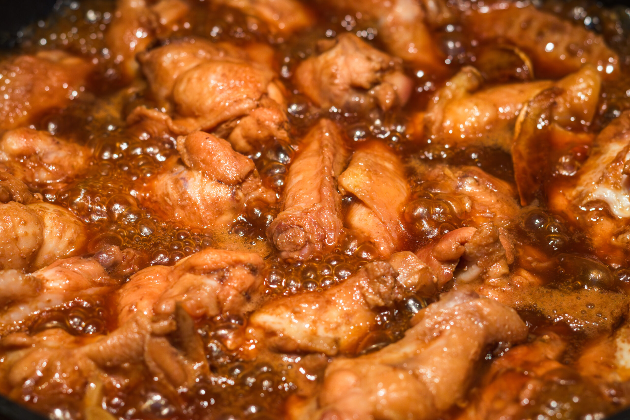 Cooking Chinese cuisine coca cola chicken wing in a pot, heating and bubbling