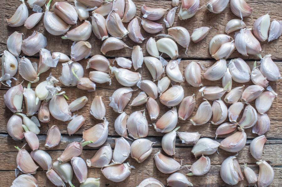 Unpeeled garlic cloves on a wooden table for background top view