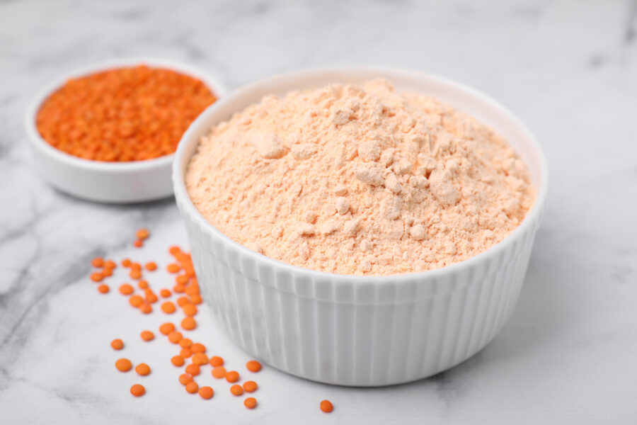 Lentil flour and seeds on white marble table, closeup