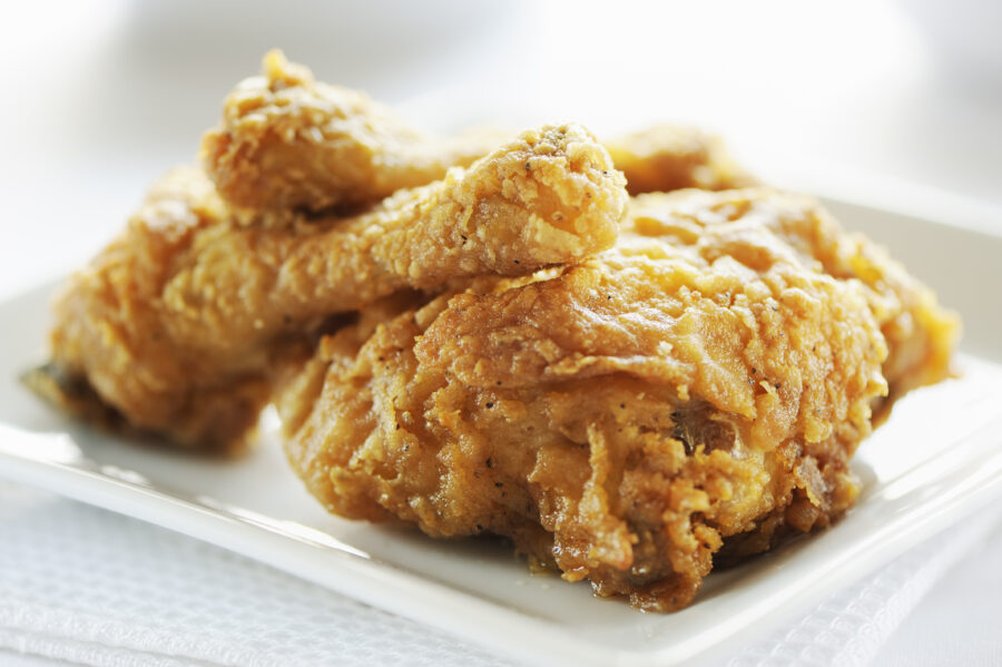 Plate of crispy fried chicken on a white background.