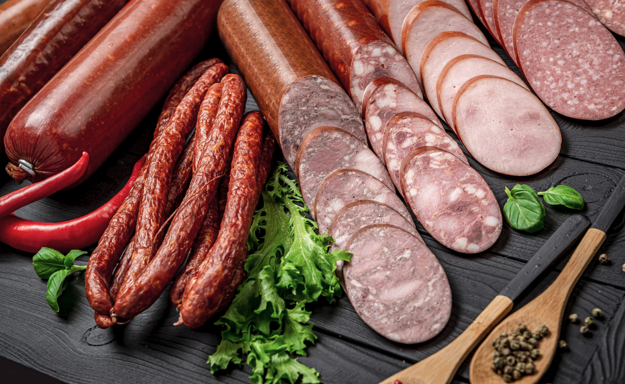 Set of different types of smoked sausage. On a dark background. Photo for the menu