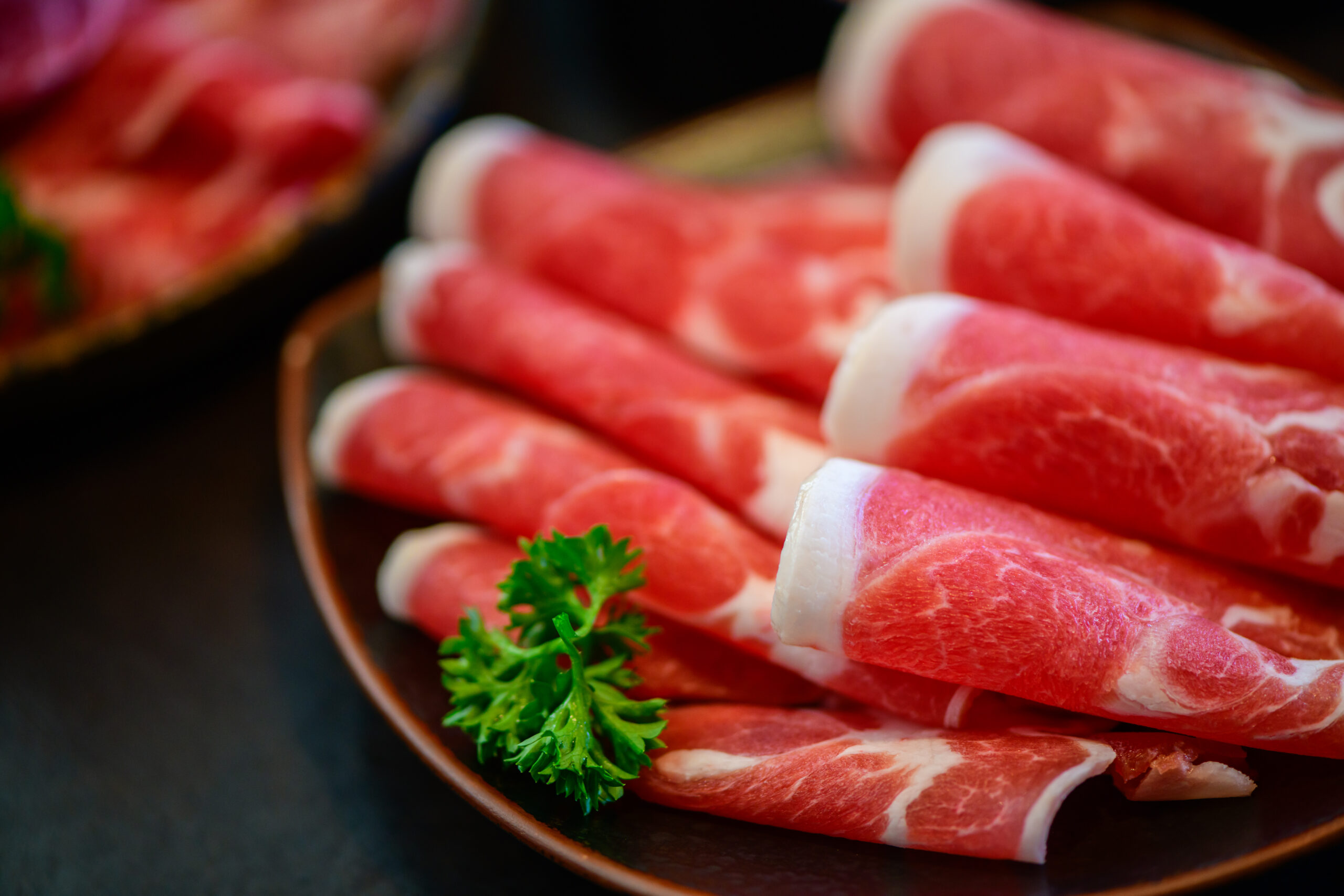 Sliced topside wagyu beef for yakiniku on plate on black background, Premium Japanese meat concept