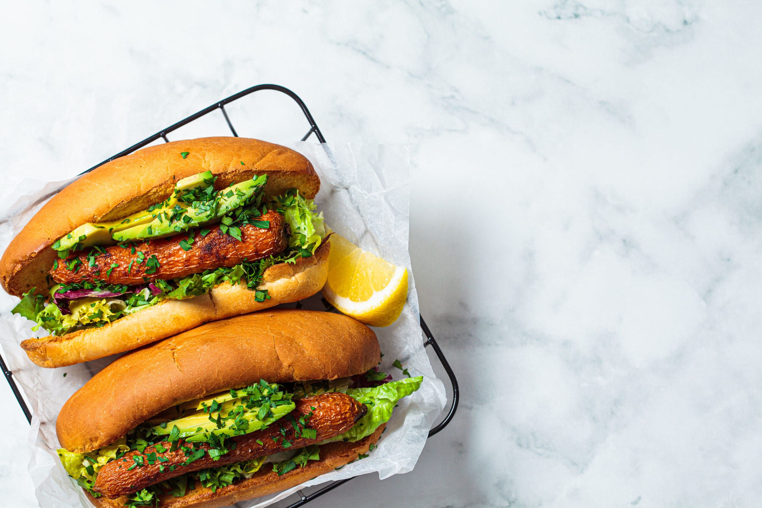 Vegan carrot hot dog with salad and avocado. Healthy food concept.