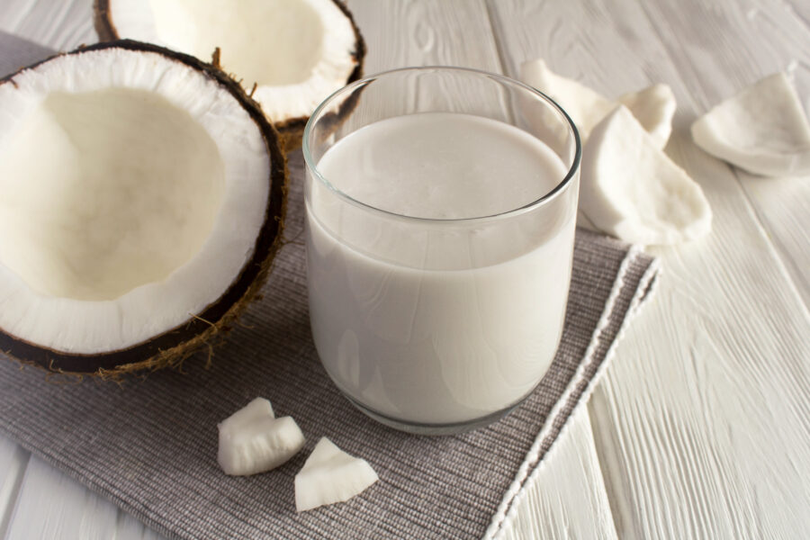 Coconut  milk in the drinking on the white background. Close-up.