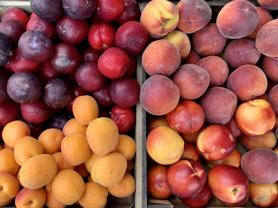 fresh organic apricot, plum, peach and nectarine in a wooden box