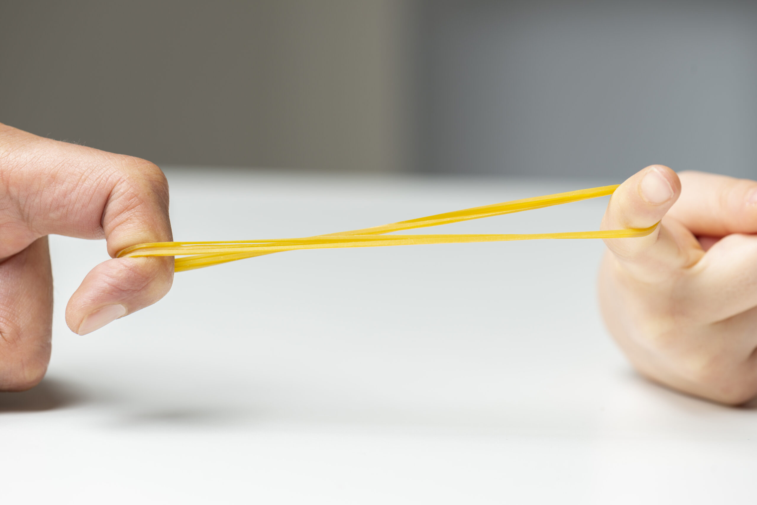 Father and her daughter are pulling rubber band. Close-up.