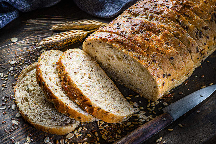 wholegrain and seeds sliced bread shot on rustic wooden table. 