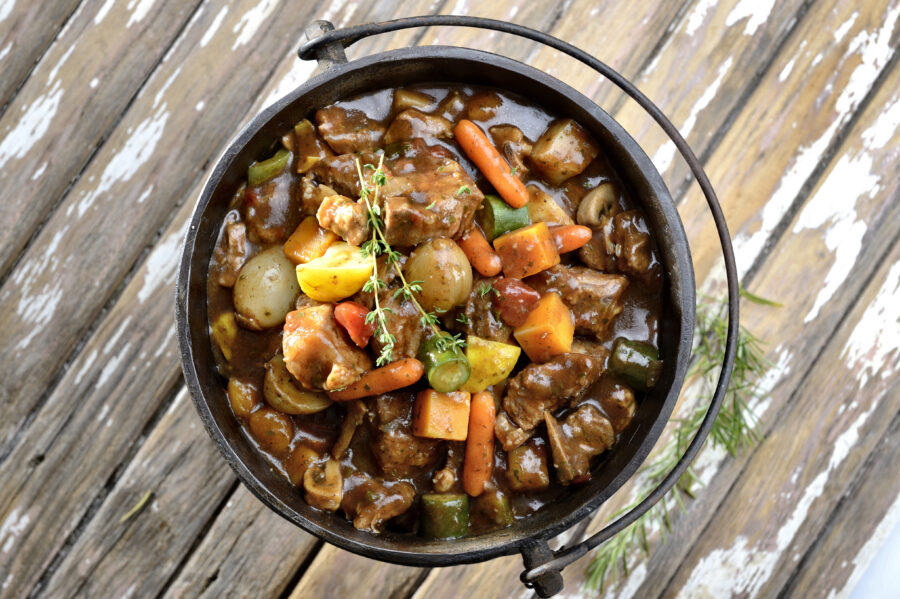 South African pot stew or potjiekos in the three-legged pot used to cook this dish on an open fire.