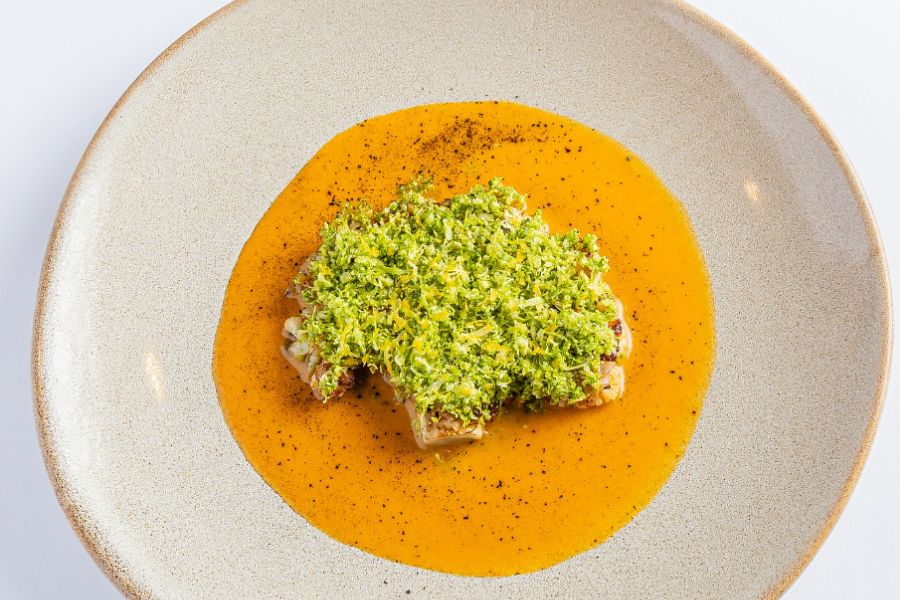 chopped fish on top of a orange soup