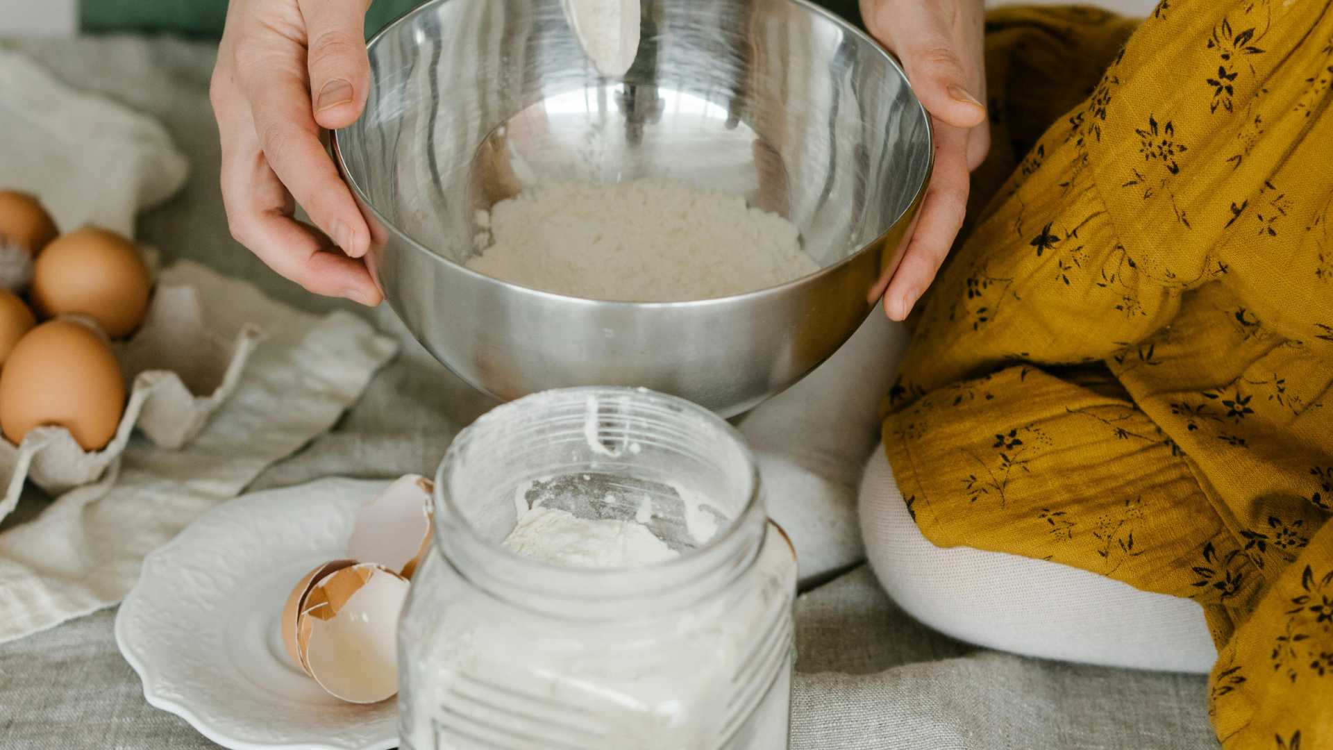 Woman holding a spoon and mixing ingredients in a kitchen