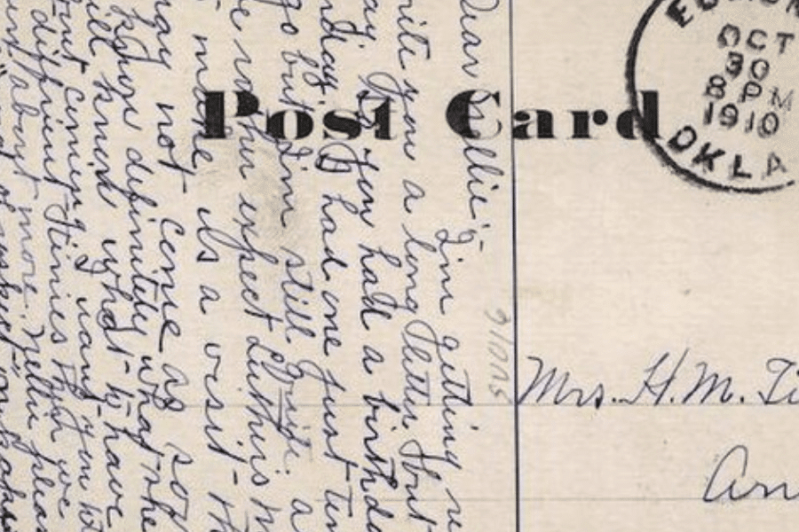 Close-up of a handwritten postcard dated October 30, 1910, from Edmond, Oklahoma. The cursive writing fills nearly the entire left side, with the word "Post Card" partially visible in bold and addressed to "Mrs. H. M. T—" on the right. The blue ink and looping penmanship convey a personal and intimate tone from the early 20th century.