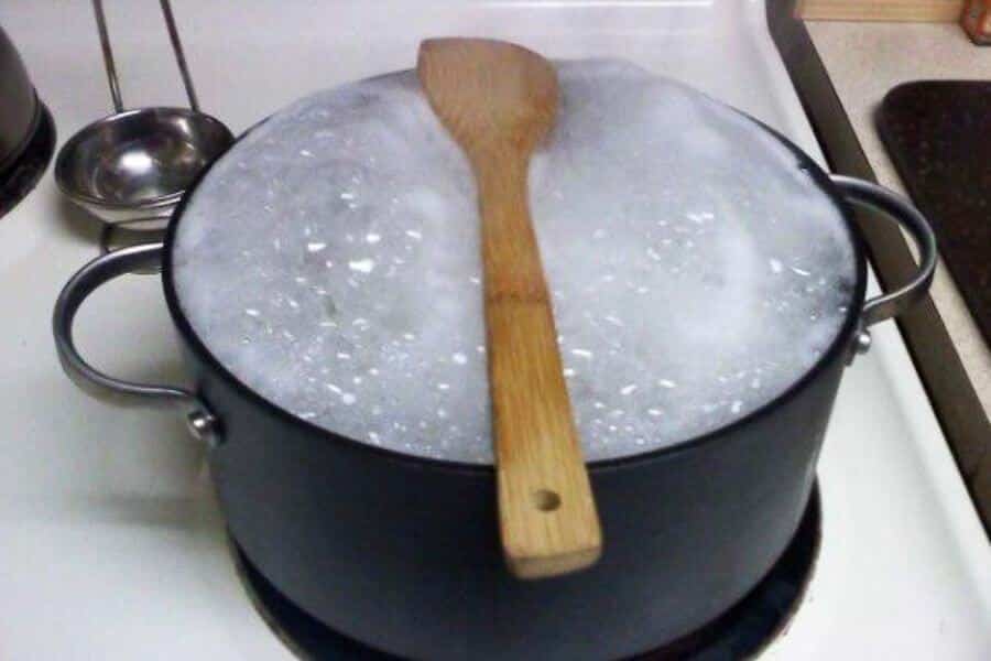 wooden spoon on top of a pot with boiling water