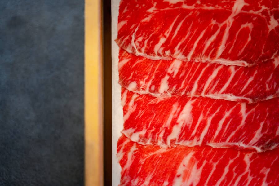 Premium raw sliced beef in wood box, repetitive