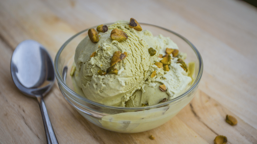 Scoop of pistachio ice cream in a clear glass bowl