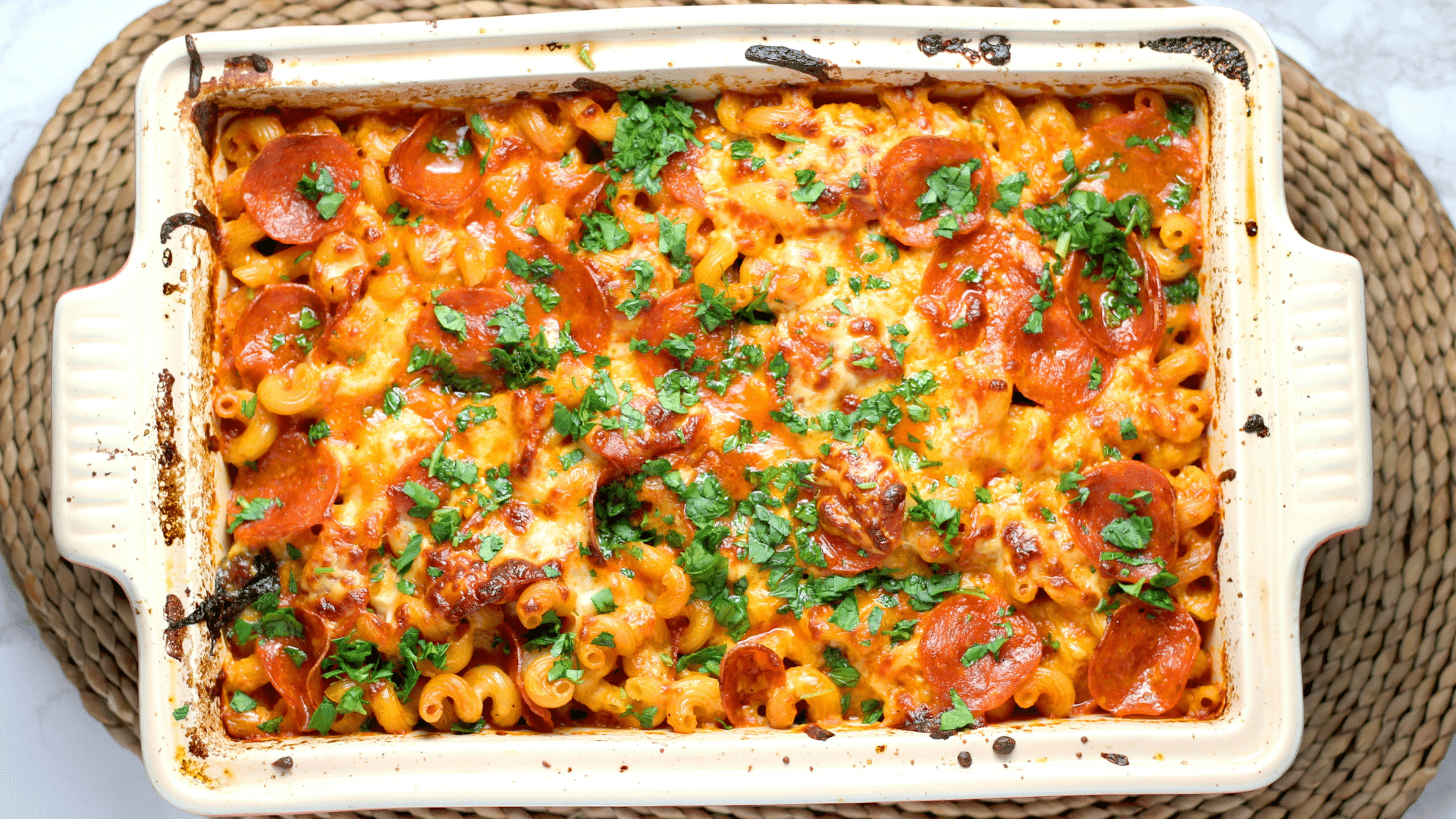 Baked casserole with melted cheese and ground beef in a white ceramic platter.