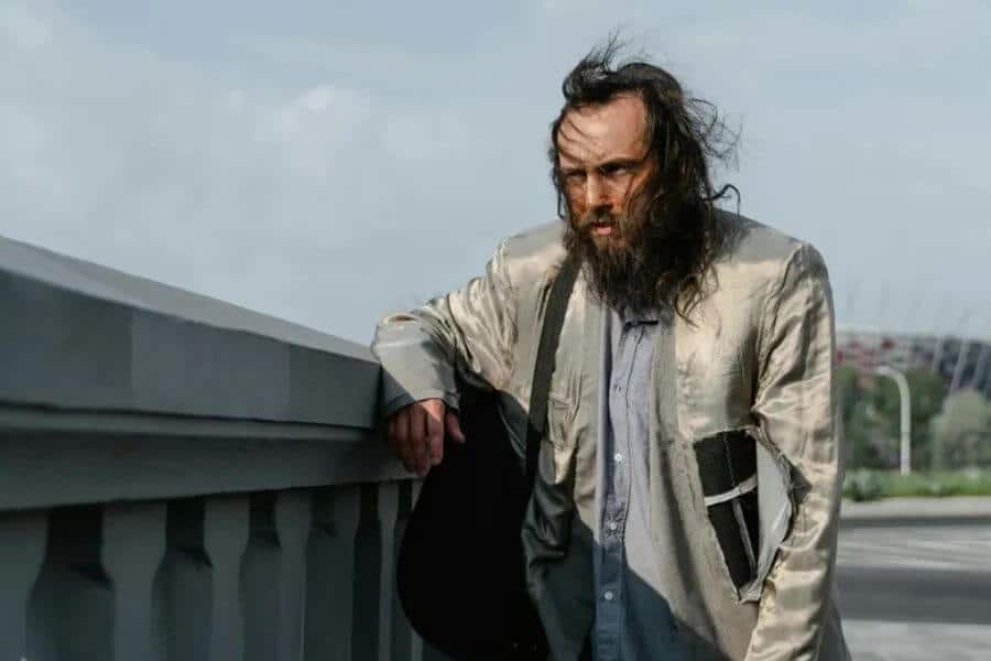 homeless man holding a bag and looking into the horizon
