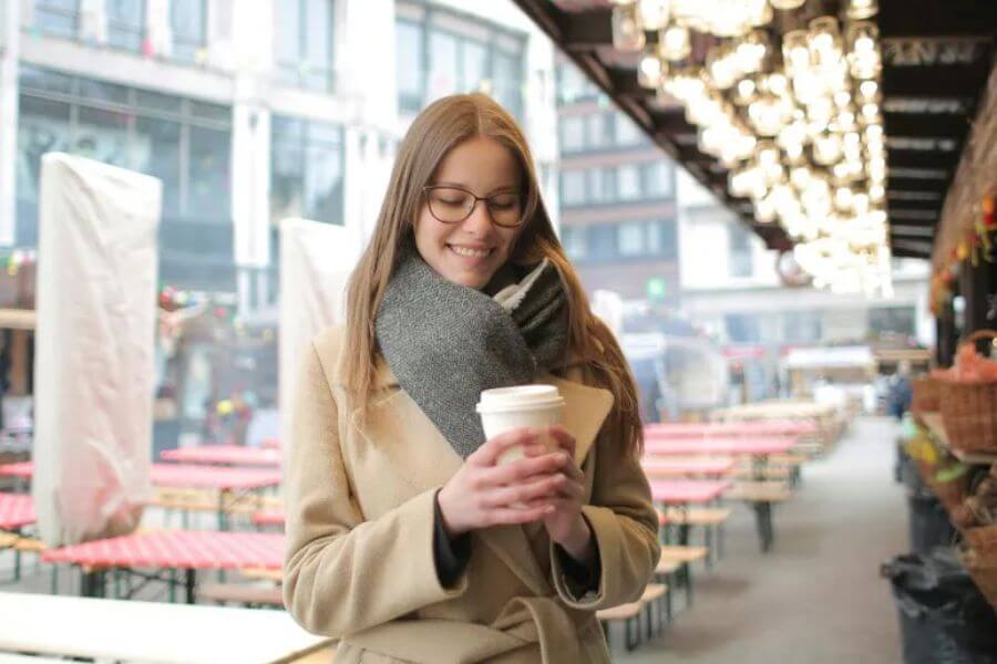 woman holding a plastic cup of coffee